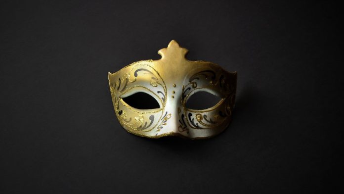 A gold mask, like a guest might wear at a masquerade ball