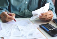 A person with bill statements as New York considers a bill that requires sportsbooks to send monthly activity statements to sports bettors.