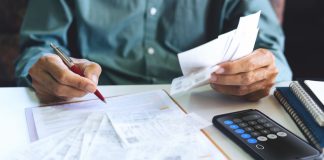 A person with bill statements as New York considers a bill that requires sportsbooks to send monthly activity statements to sports bettors.