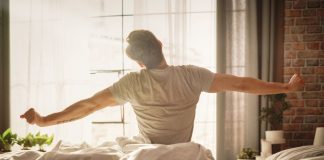 Sleeper re-awakens as prediction market through deal with Kalshi A man sits up and stretches in bed after waking up