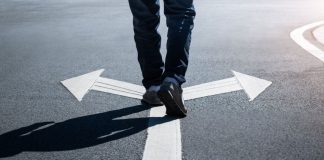 Virginia punts sweeps ban to 2027 as Indiana moves ahead A person walking on a road over arrows pointing in opposite directions