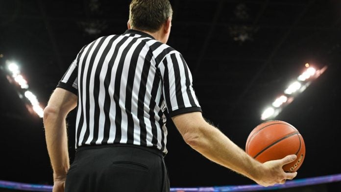 A basketball referee holding a ball