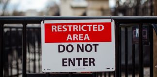 A "restricted area" sign on a gate