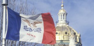 The Iowa flag flies in front of the State Capitol building