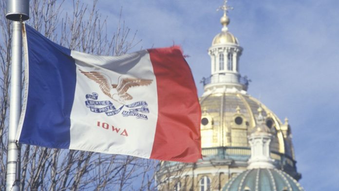 The Iowa flag flies in front of the State Capitol building