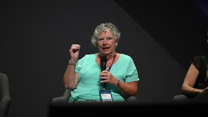 Sue Schneider speaking on stage