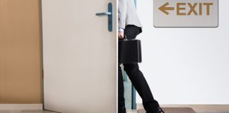 A person walking out of an exit door