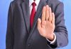 A person holding out their hand in a 'stop' gesture