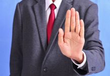 A person holding out their hand in a 'stop' gesture