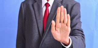 A person holding out their hand in a 'stop' gesture