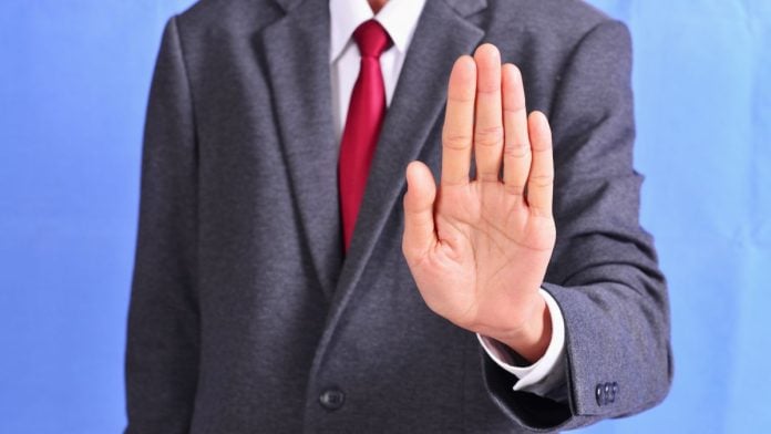Judge-pauses-Arizonas-criminal-case-against-Kalshi-after-CFTC-steps-in A person holding out their hand in a 'stop' gesture