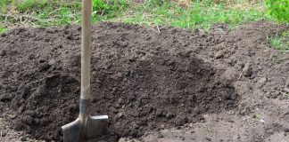 A shovel in the ground digging a hole
