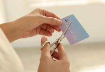 A person cutting a credit card as Ohio considers a regulatory credit card ban.