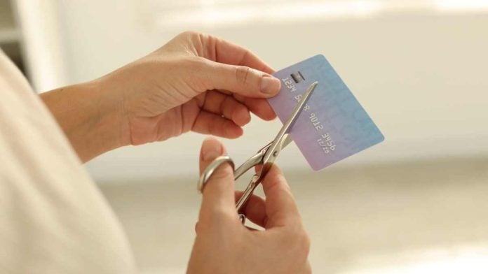 Ohio-Proposed-Rule-Change A person cutting a credit card as Ohio considers a regulatory credit card ban.