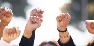As CFTC outlines sports prediction markets rules, states and tribes take action People with arms raised in protest