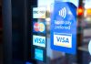 Florida tells payment giants: Stop working with illegal gambling sites Signs for Visa, Mastercard, and American Express on a shop door