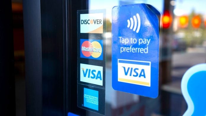 Signs for Visa, Mastercard, and American Express on a shop door