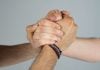 Three people joining hands