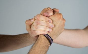 Prediction market giants unite to sue Kentucky over planned tax Three people joining hands