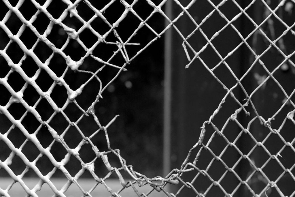A fence with a big hole in it