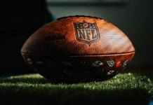 NFL football on grass in dark light